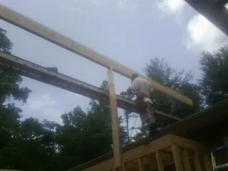Carpenter setting a ridge beam over a new addition frame — Ice Dam Removal by Roofing Brothers in Point Pleasant
