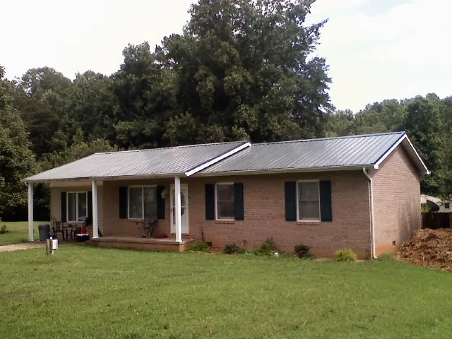 Gray metal roof on a brick ranch house with a side carport in Point Pleasant