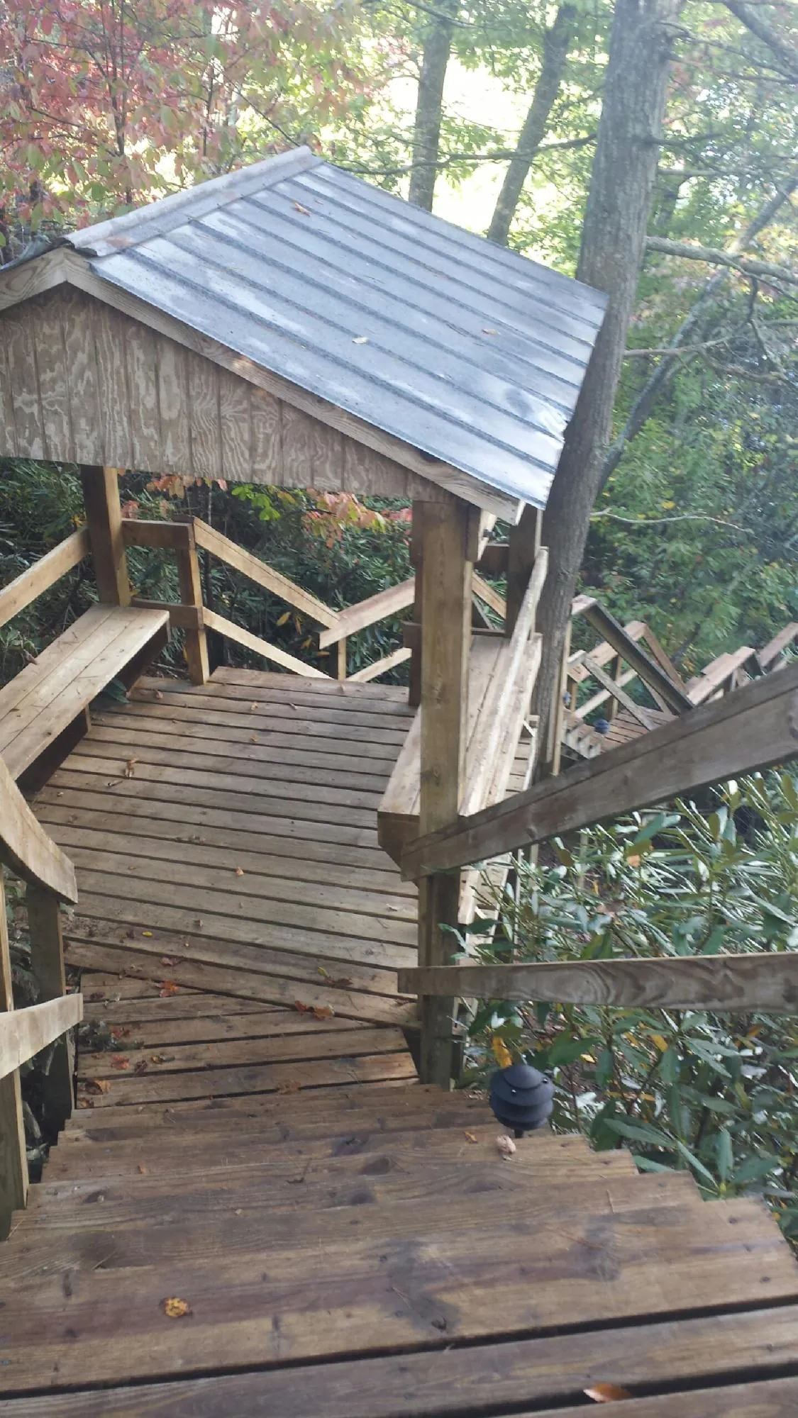 Metal roofed shelter over wooden steps on a wooded walkway — Skylight Repair & Installation work by our crew in Point Pleasant